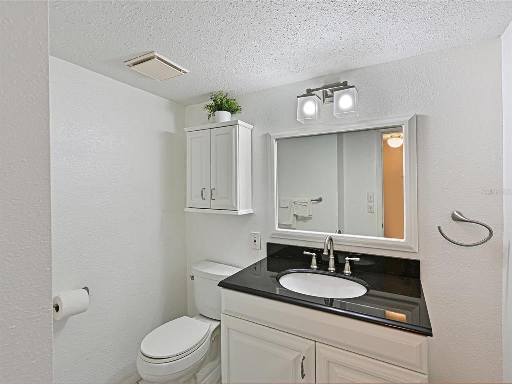 5400 34th Street West, Unit I9 Bradenton, FL 34210 - Photo 20 of 39 a bathroom with a granite countertop sink a toilet and a mirror