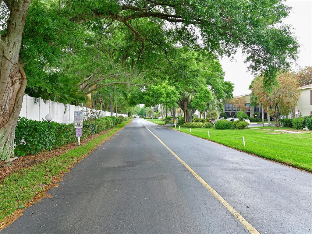 5400 34th Street West, Unit I9 Bradenton, FL 34210 - Photo 37 of 39 a view of a street with a yard and large trees