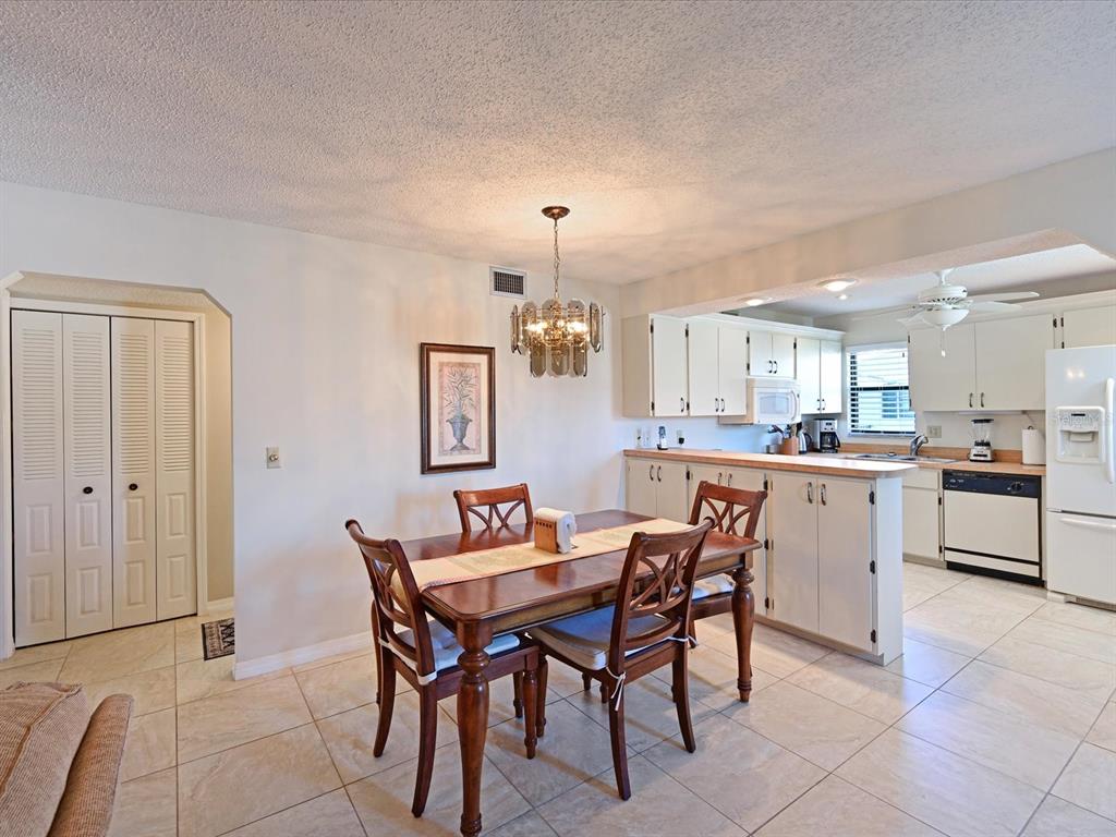 5400 34th Street West, Unit I9 Bradenton, FL 34210 - Photo 5 of 39 a kitchen with a dining table chairs and refrigerator