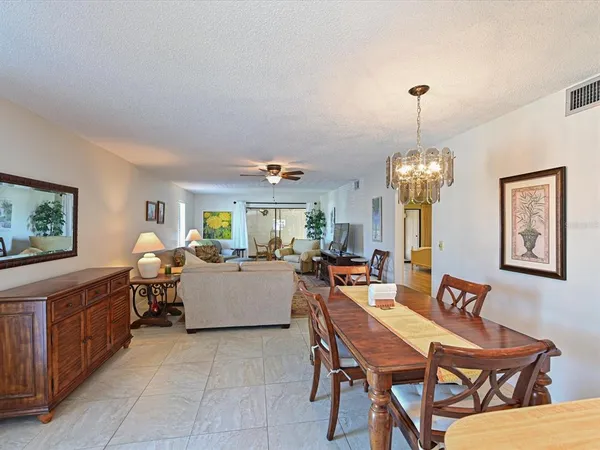 a dining room with furniture a chandelier and window