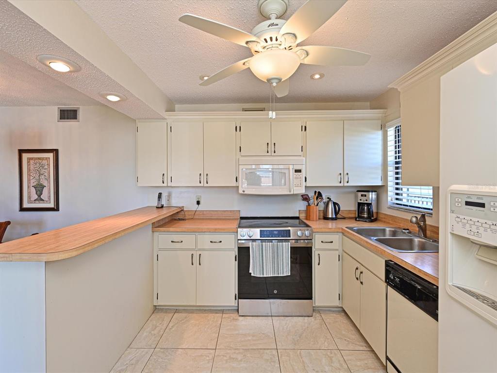 5400 34th Street West, Unit I9 Bradenton, FL 34210 - Photo 9 of 39 a kitchen with a stove sink and cabinets