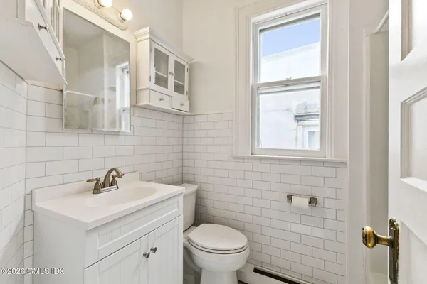 a bathroom with a sink a toilet and a mirror