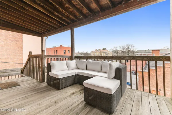 a roof deck with couches and wooden floor
