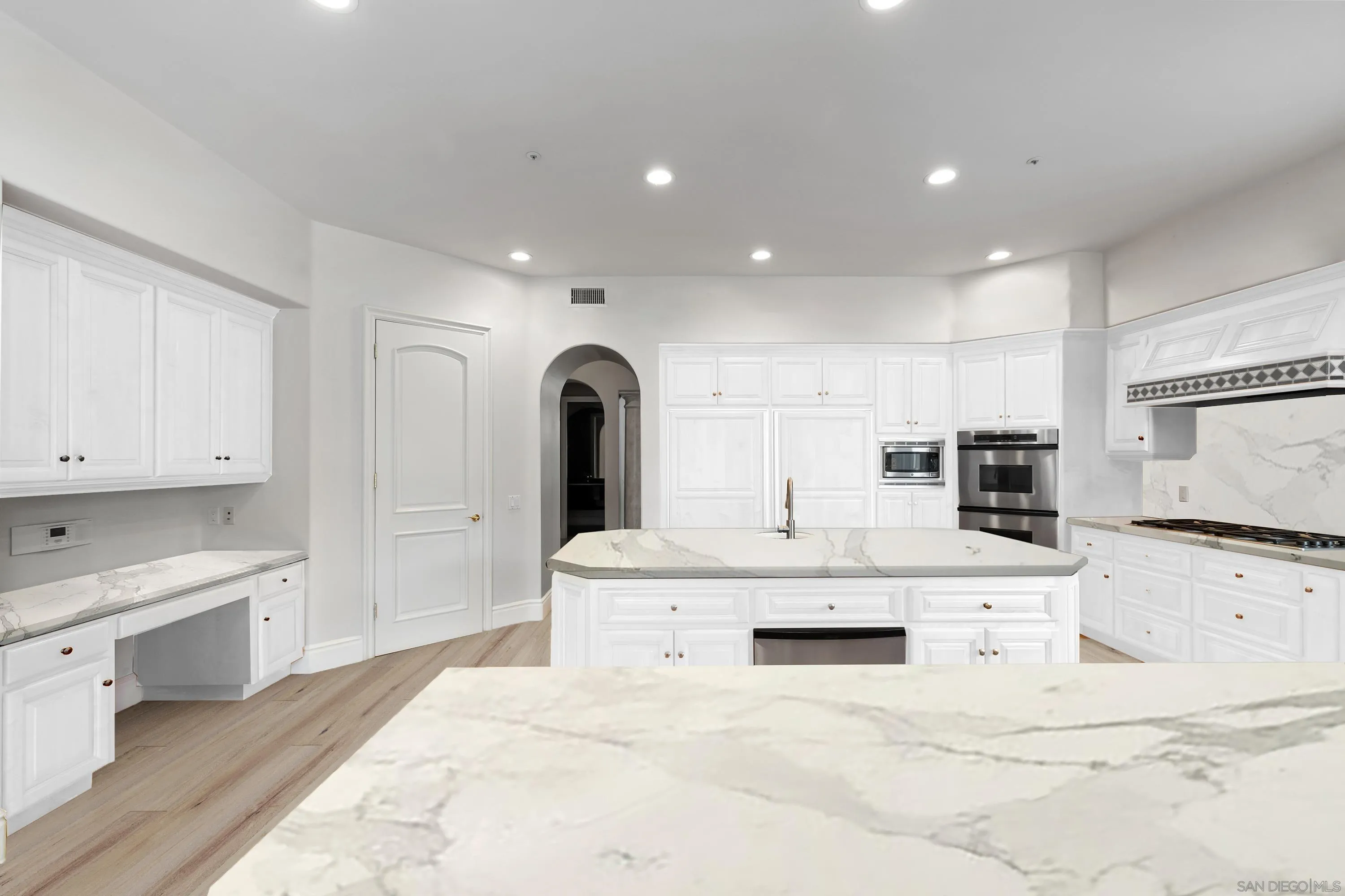 18050 Rancho La Cima Corte Rancho Santa Fe, CA 92067 - Photo 22 of 57 a large white kitchen with kitchen island a sink a stove a refrigerator and white cabinets