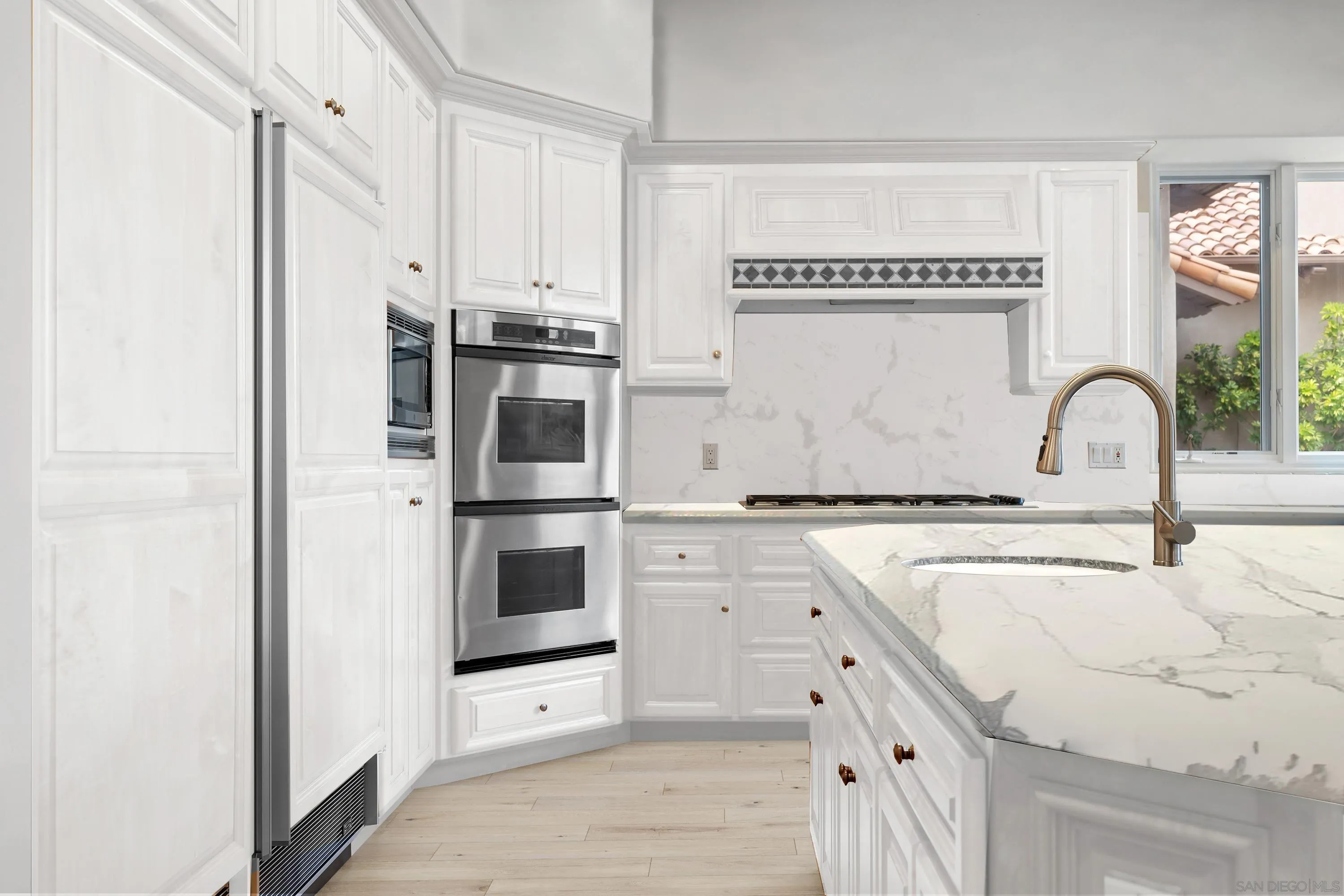 18050 Rancho La Cima Corte Rancho Santa Fe, CA 92067 - Photo 23 of 57 a kitchen with stainless steel appliances granite countertop a sink and a refrigerator