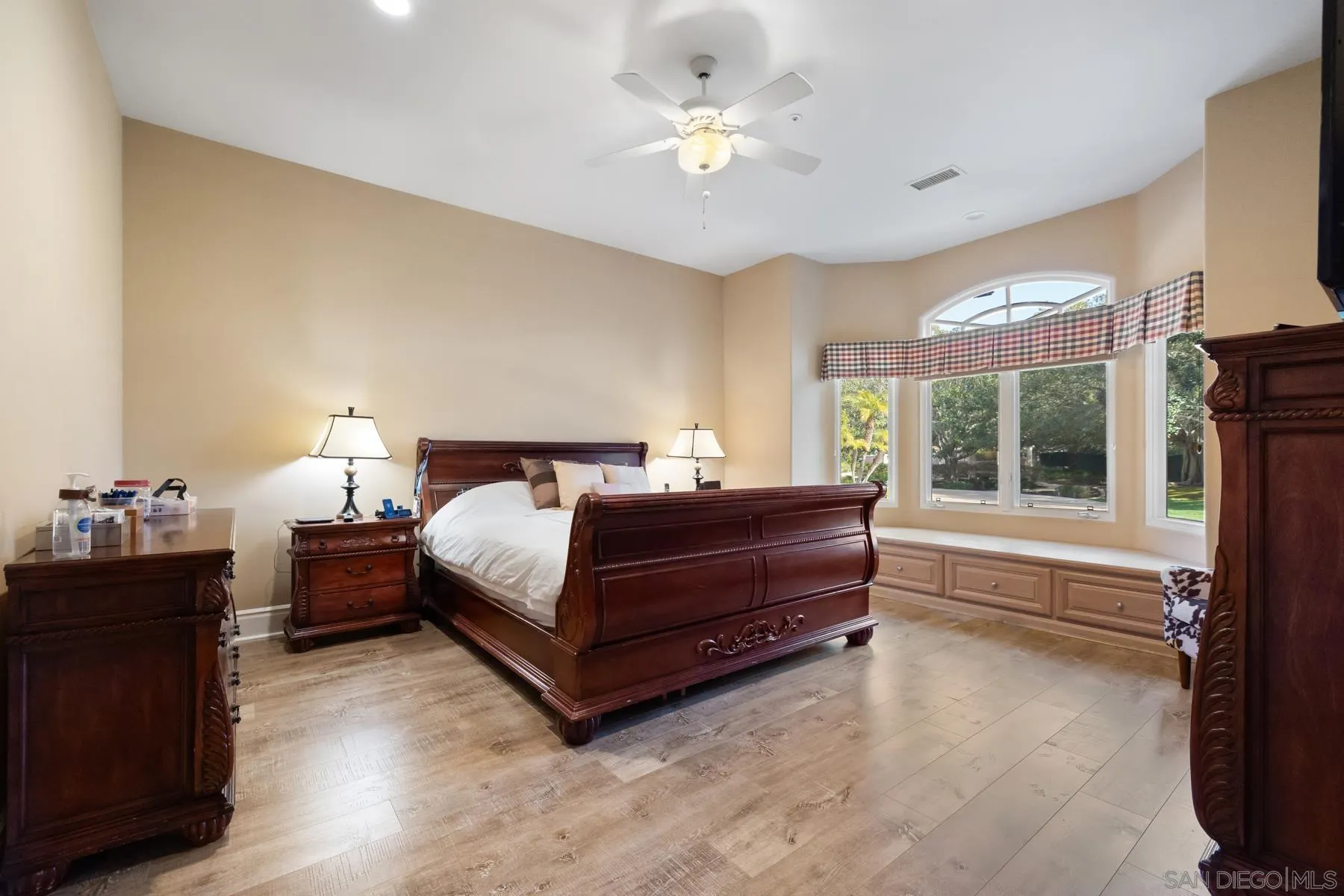 18050 Rancho La Cima Corte Rancho Santa Fe, CA 92067 - Photo 33 of 57 a bedroom with a large bed and a chandelier next to a window