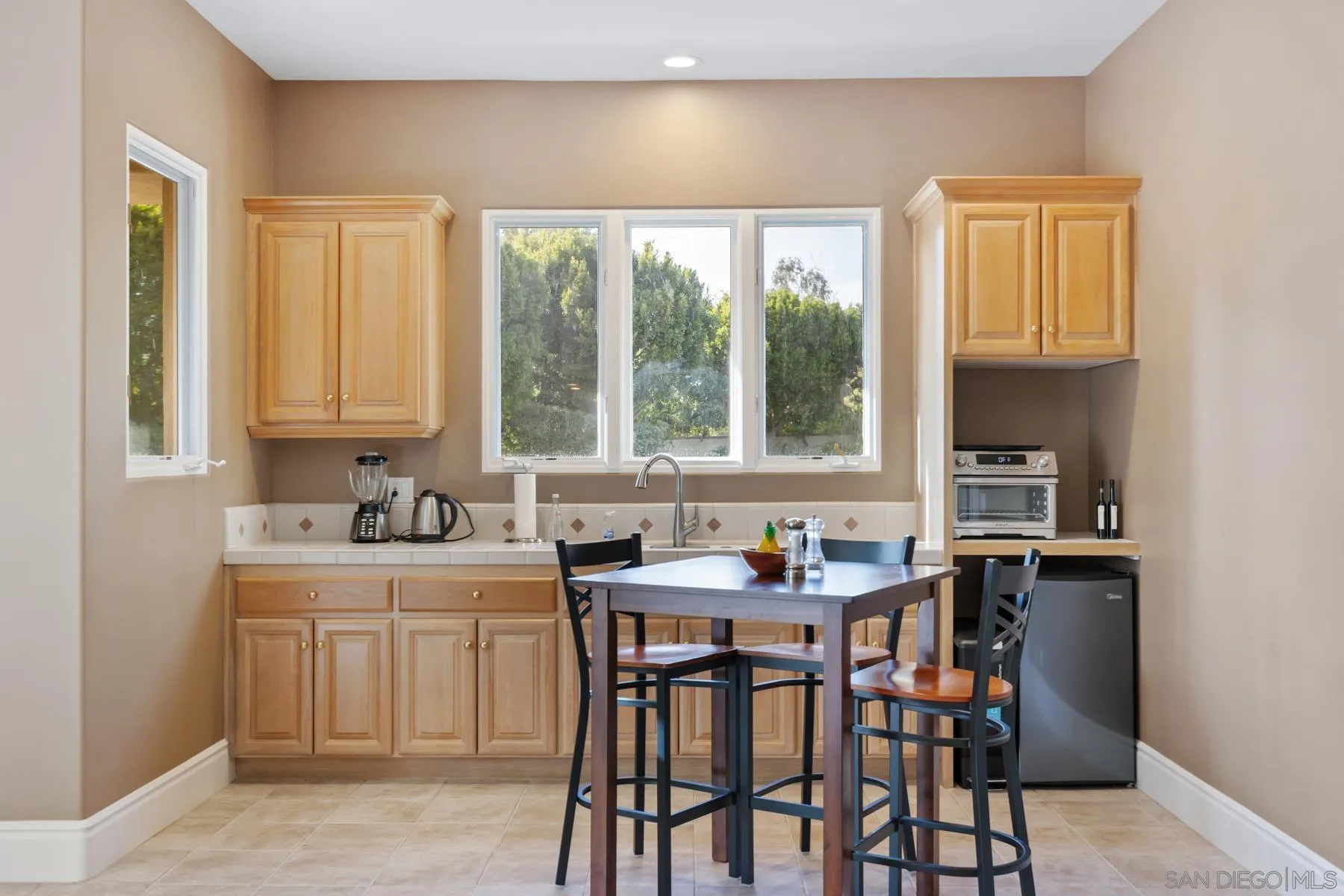 18050 Rancho La Cima Corte Rancho Santa Fe, CA 92067 - Photo 48 of 57 a kitchen with a table chairs sink and cabinets