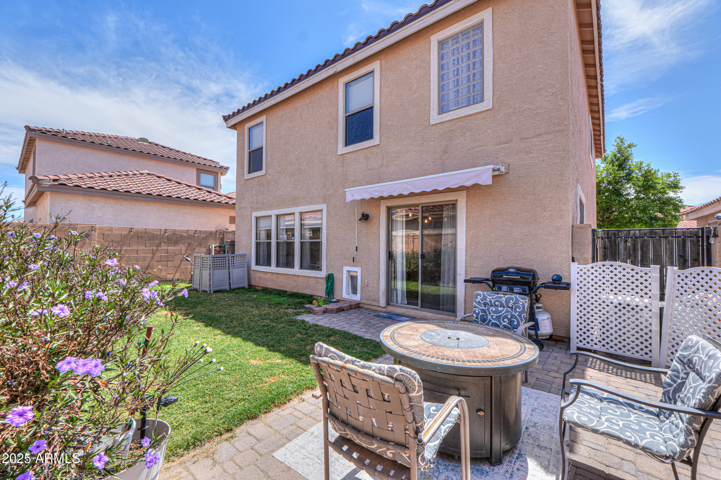 a view of a chairs and table in backyard of the house