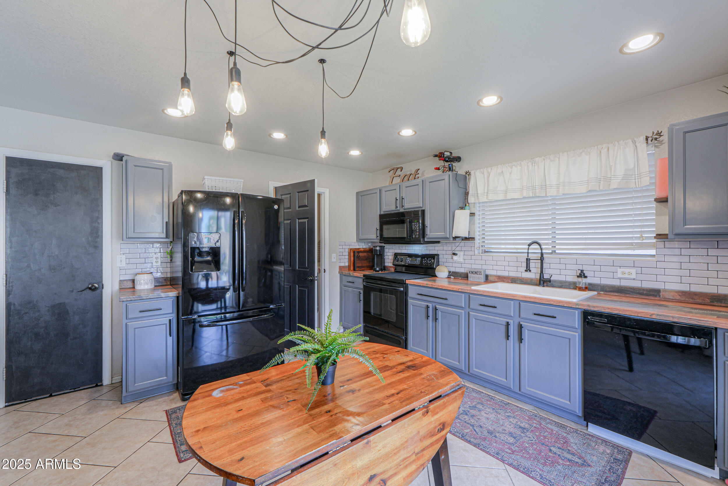 3433 South Chaparral Road Apache Junction, AZ 85119 - Photo 12 of 37 a kitchen with stainless steel appliances granite countertop a sink a stove a refrigerator cabinets and wooden floor