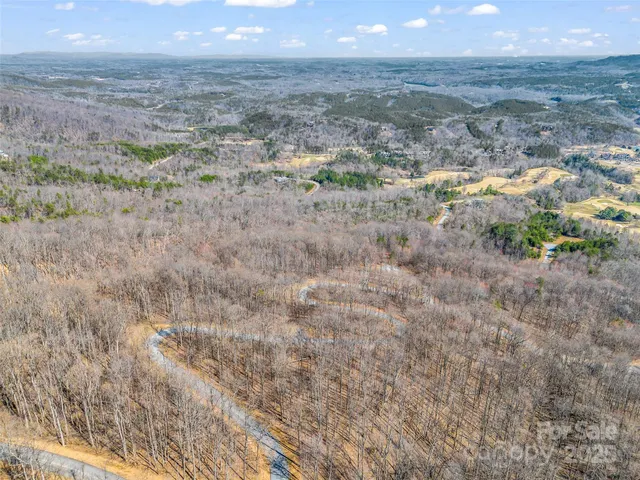 a view of a dry field with mountains in the background