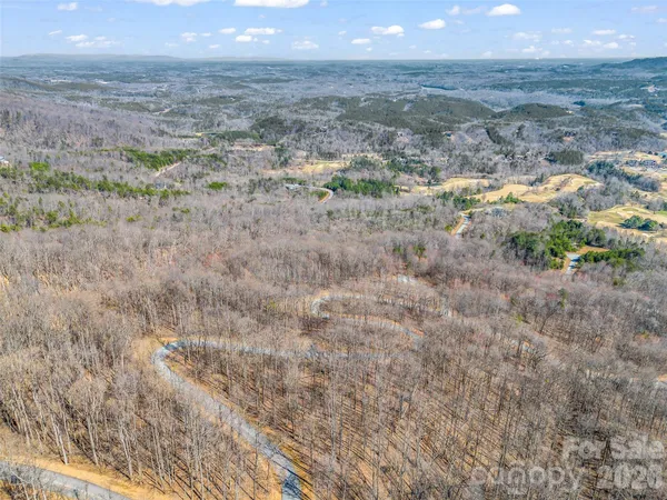 a view of a dry field with mountains in the background