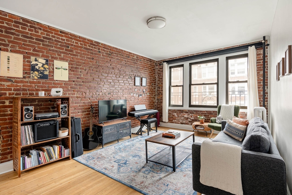 111 Jersey Street, Unit 12 Boston, MA 02215 - Photo 1 of 17 a living room with furniture a flat screen tv and a refrigerator