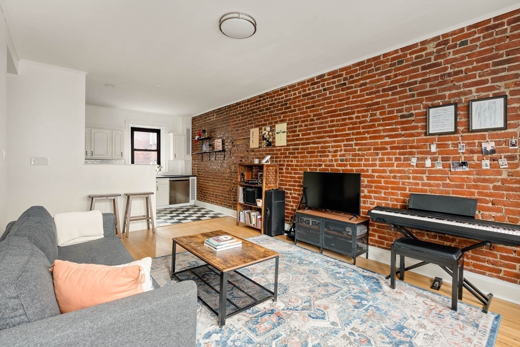 111 Jersey Street, Unit 12 Boston, MA 02215 - Photo 2 of 17 a living room with furniture a flat screen tv a rug and a fireplace