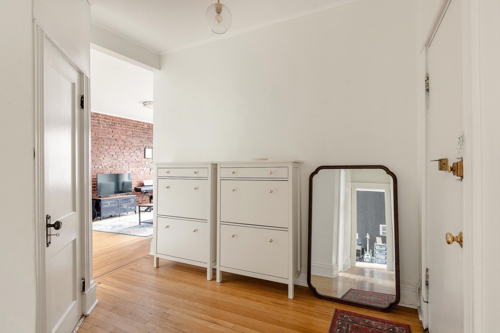 111 Jersey Street, Unit 12 Boston, MA 02215 - Photo 8 of 17 a view of a hallway with wooden floor and a living room