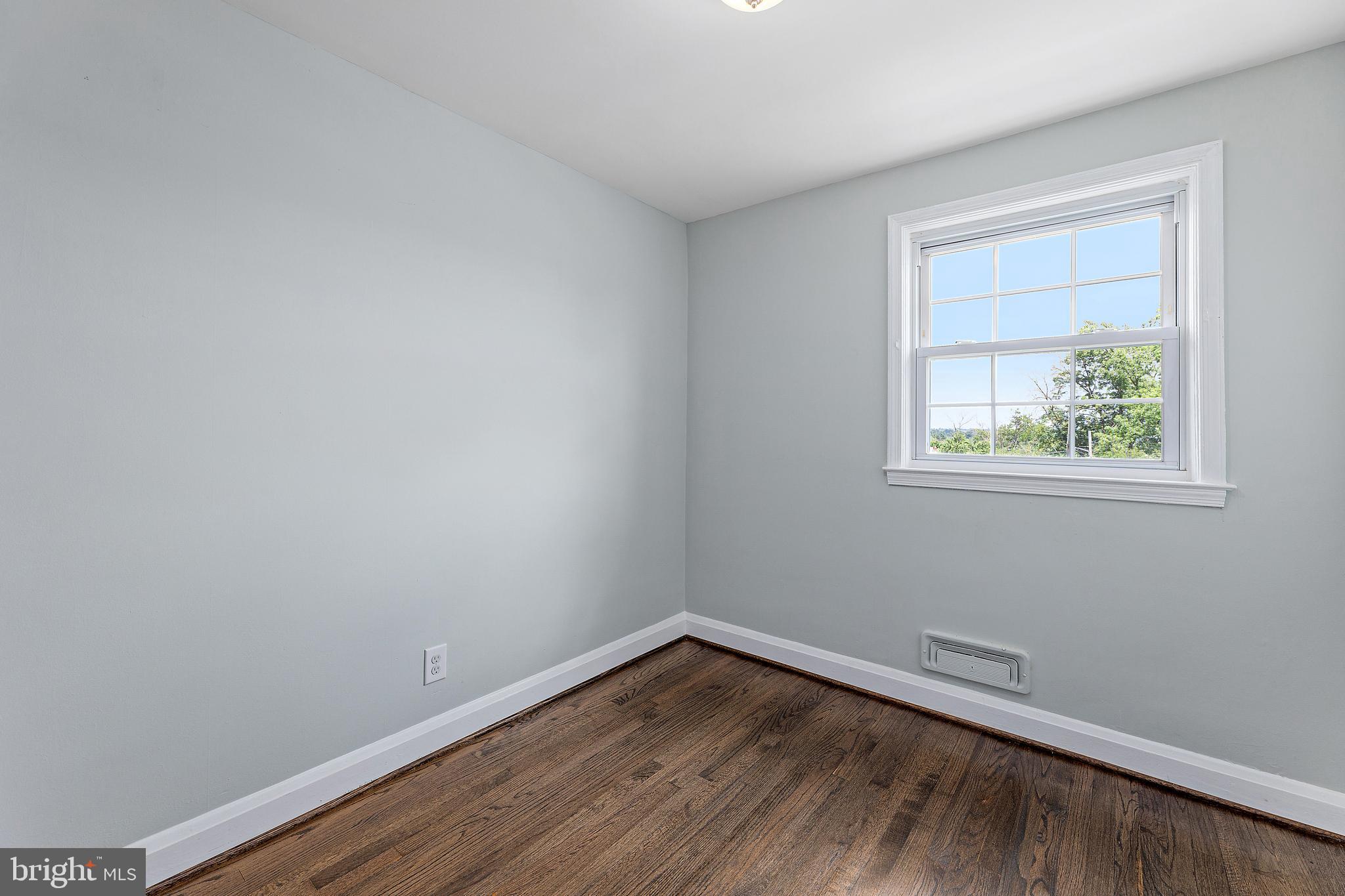 1206 Newfield Road Gwynn Oak, MD 21207 - Photo 14 of 26 a view of an empty room with wooden floor and a window