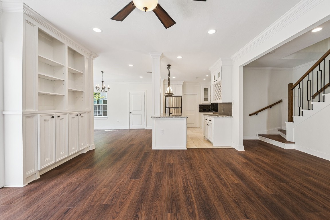 3071 Locke Lane Houston, TX 77019 - Photo 11 of 44 The spacious family room features neutral designer paint, a custom-tiled fireplace, ceiling fan, built-in cabinetry, and elegant crown molding. Open to the kitchen, sunroom, and dining area, it provides a seamless and inviting space for family gatherings and entertaining.