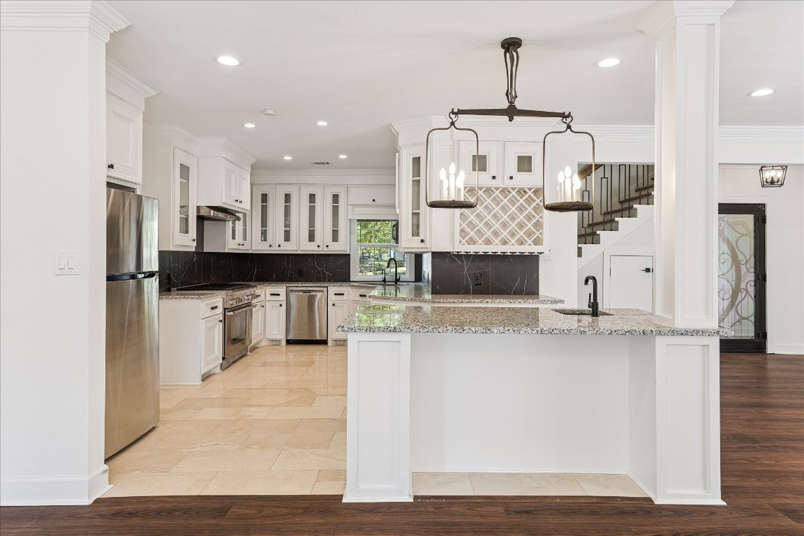 3071 Locke Lane Houston, TX 77019 - Photo 12 of 44 This kitchen showcases granite countertops, tile flooring, and neutral designer wall paint, creating a timeless and inviting space. A Thermador gas range, stainless steel appliances, and built-in wine rack shelving complement the island with breakfast bar seating, all open to the family and breakfast rooms.