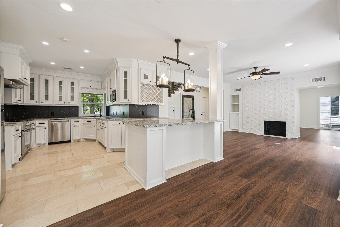 3071 Locke Lane Houston, TX 77019 - Photo 13 of 44 This bright, open kitchen features granite countertops, tile flooring, and a Thermador gas range, perfect for the home chef. The island with breakfast bar seating flows seamlessly into the family room, creating an inviting space for cooking and entertaining.
