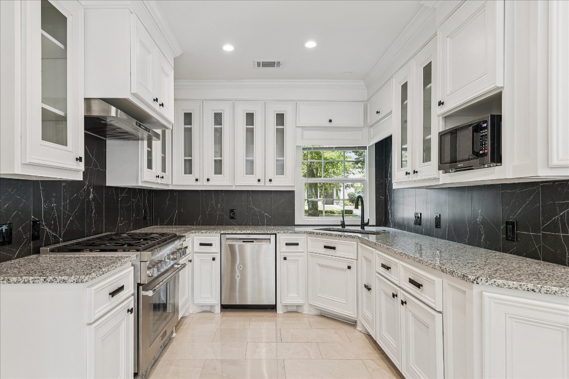 3071 Locke Lane Houston, TX 77019 - Photo 15 of 44 This bright, open kitchen features granite countertops, tile flooring, and a Thermador gas range, perfect for the home chef. The island with breakfast bar seating flows seamlessly into the family room, creating an inviting space for cooking and entertaining.