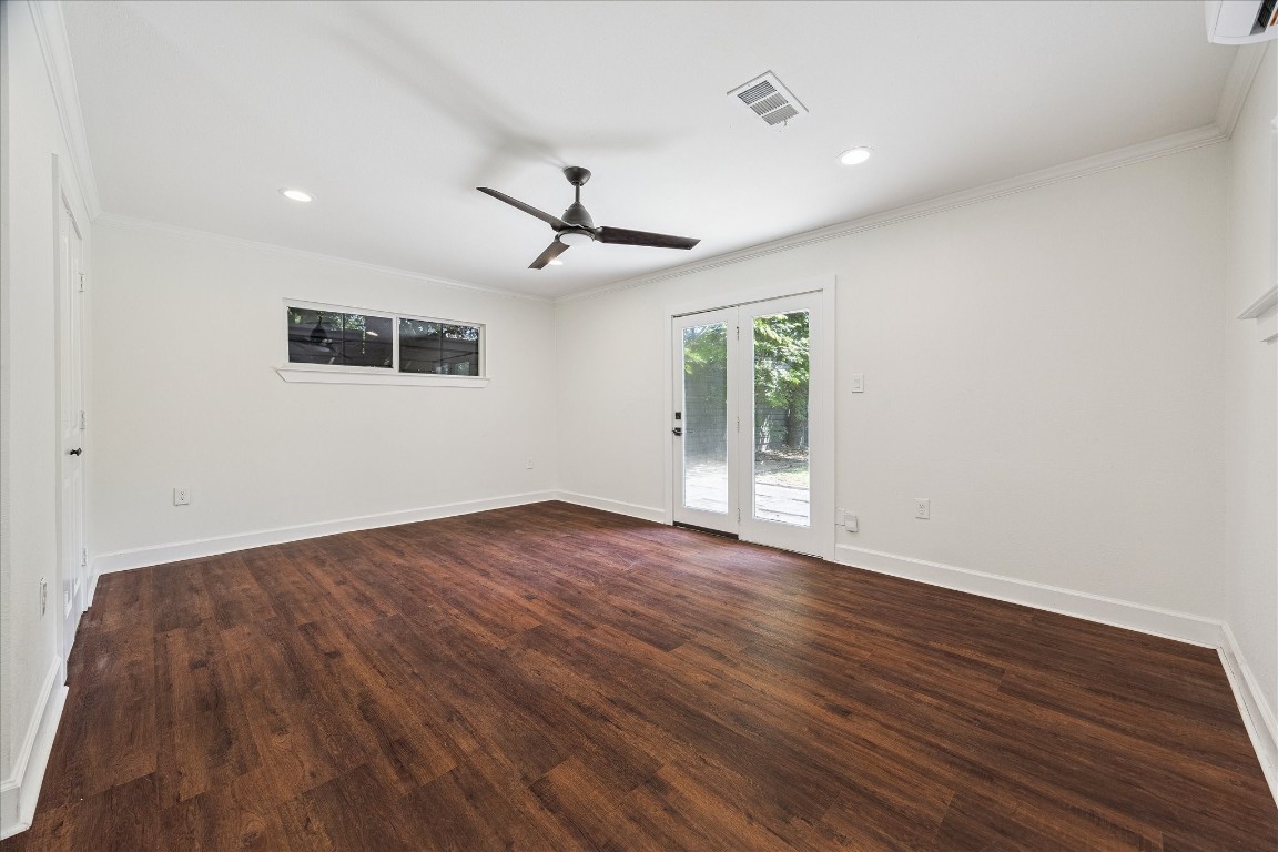3071 Locke Lane Houston, TX 77019 - Photo 23 of 44 This first-floor primary suite features neutral wall paint and French doors that open to the backyard, filling the room with natural light from southern, eastern, and western exposures. The ensuite bathroom includes recessed lighting and a ceiling fan, creating a comfortable and relaxing retreat.