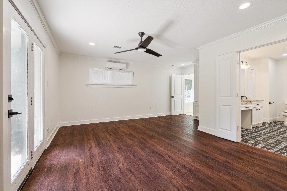 3071 Locke Lane Houston, TX 77019 - Photo 24 of 44 Elegant and spacious, the primary suite on the first floor offers neutral walls, abundant windows with southern, eastern, and western exposure, and French doors leading to the backyard. The ensuite bathroom is equipped with recessed can lighting and a ceiling fan, combining style and functionality.