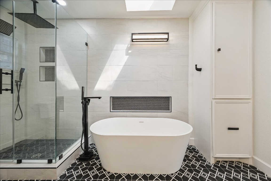 3071 Locke Lane Houston, TX 77019 - Photo 25 of 44 A true retreat, this bathroom includes a walk-in shower with rainfall showerhead and shower wand, a soaking tub, and double vanities with granite countertops. Designer tile flooring completes the luxurious, well-appointed space.