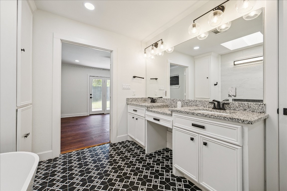 3071 Locke Lane Houston, TX 77019 - Photo 26 of 44 Spacious and elegant, the primary bath offers double sinks with ample vanity space and vanity lighting, complemented by granite countertops and designer tile flooring for a polished, functional design.