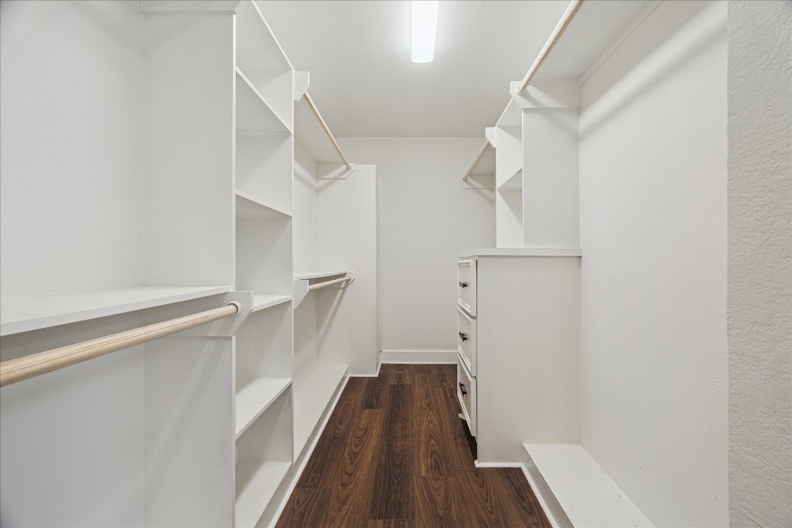 3071 Locke Lane Houston, TX 77019 - Photo 28 of 44 The first-floor primary closet is thoughtfully designed for organization, featuring double-level hanging rods, built-in shelving, and a built-in dresser, providing ample storage and easy access for clothing and accessories.