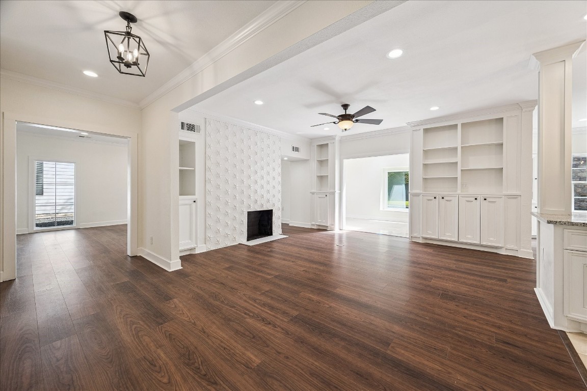 3071 Locke Lane Houston, TX 77019 - Photo 4 of 44 Open and airy, this family room flows seamlessly to the kitchen, sunroom, and dining area. Features include neutral designer walls, a custom-tiled fireplace, ceiling fan, built-in cabinetry, and refined crown molding for a polished, cohesive look.