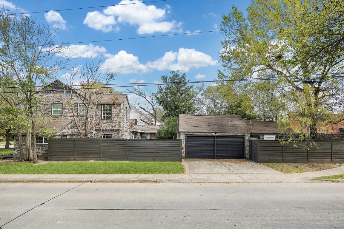 3071 Locke Lane Houston, TX 77019 - Photo 42 of 44 The side view highlights the two-car garage and the attached first-floor guest suite, showcasing convenient access and a functional layout that combines parking, storage, and flexible living space.