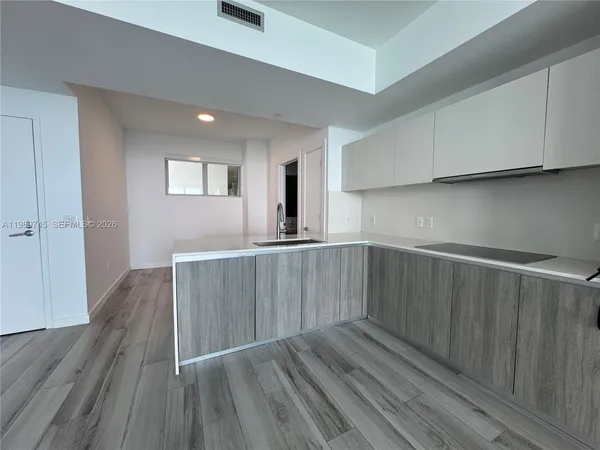 a view of kitchen with wooden floor electronic appliances and window