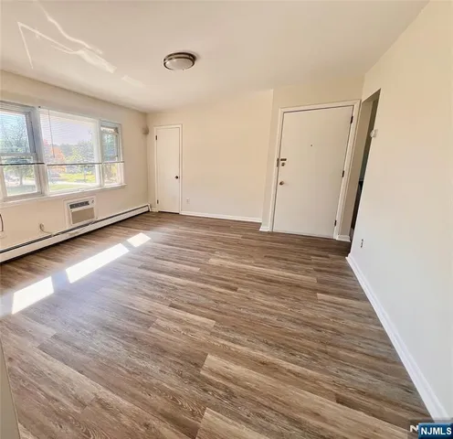 a view of a room with wooden floor and window