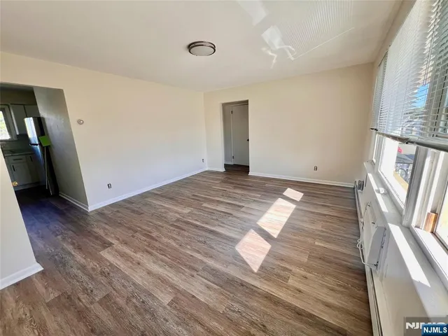 an empty room with wooden floor and entrance