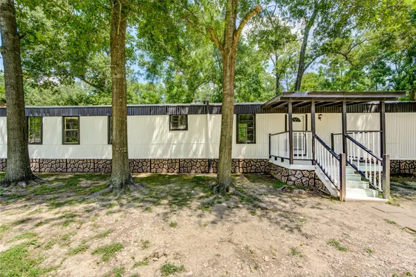 a view of backyard with wooden fence and a large tree