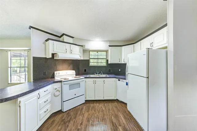 a kitchen with white cabinets and white appliances