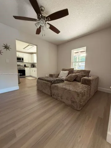 a living room with furniture and a ceiling fan