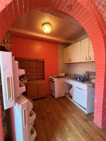 a kitchen with a sink wooden floor and a stove