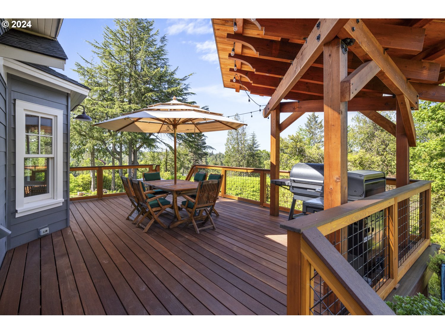 3029 Southwest Sunset Boulevard Portland, OR 97239 - Photo 34 of 48 a view of a roof deck with table and chairs under an umbrella with wooden floor