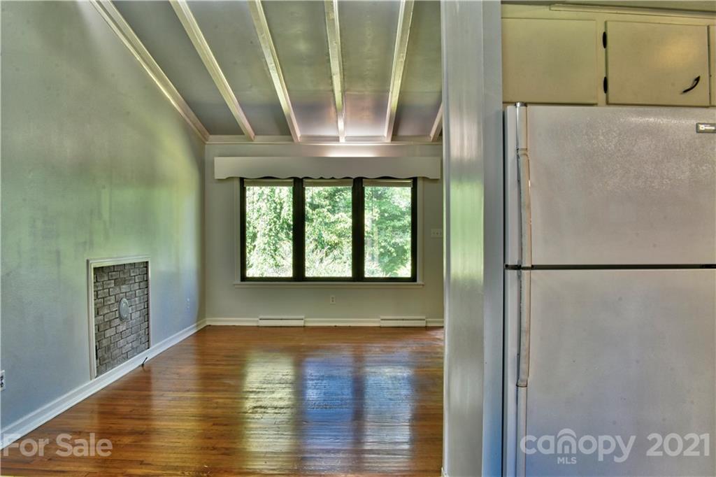700 Mountain Creek Road Albemarle, NC 28001 - Photo 7 of 48 a view of a hallway with wooden floor and a refrigerator