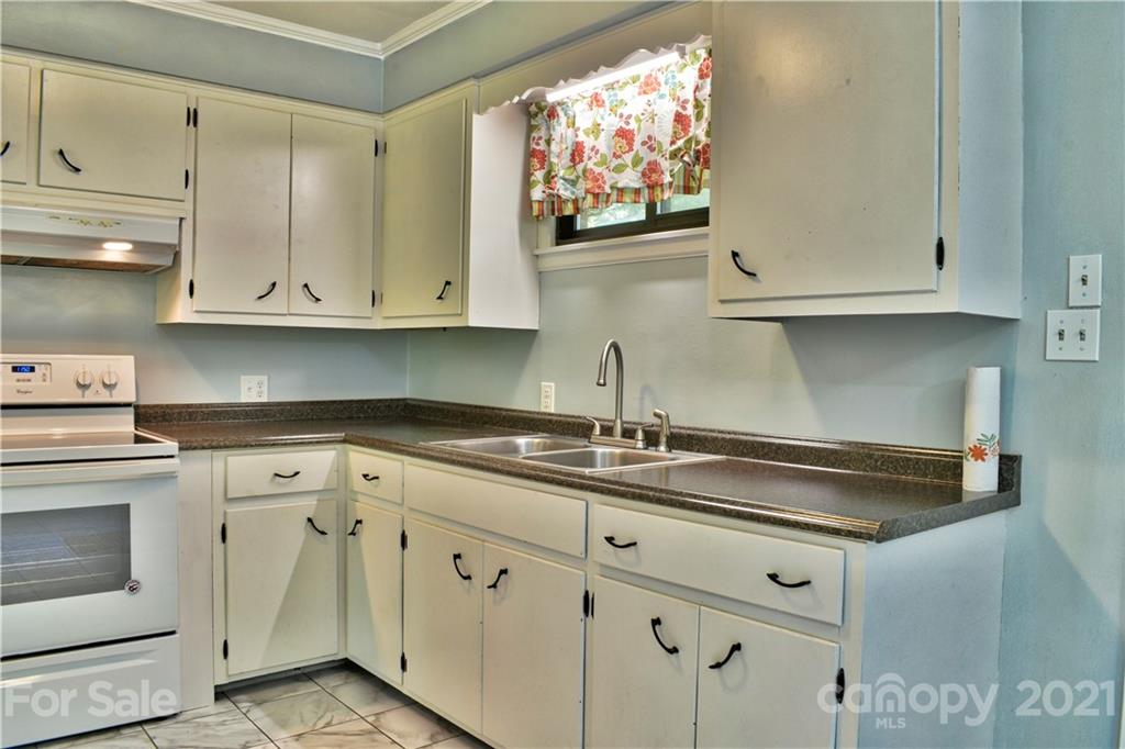 700 Mountain Creek Road Albemarle, NC 28001 - Photo 8 of 48 a kitchen with granite countertop white cabinets and a stove