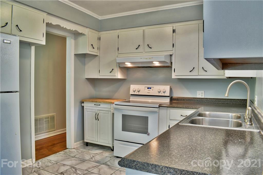 700 Mountain Creek Road Albemarle, NC 28001 - Photo 9 of 48 a kitchen with white cabinets and a stove