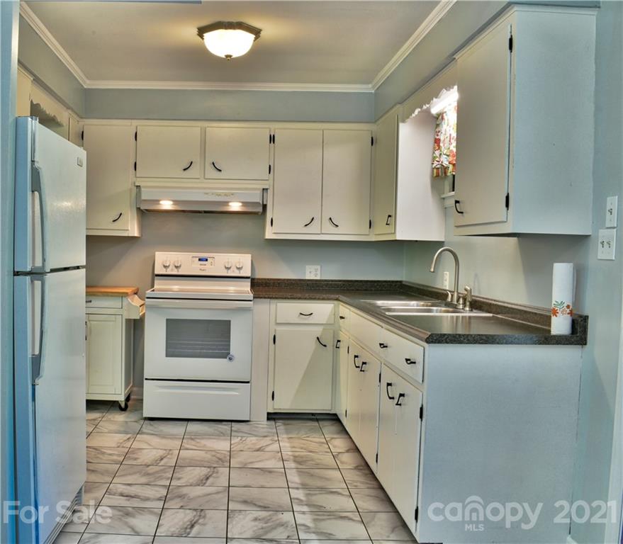 700 Mountain Creek Road Albemarle, NC 28001 - Photo 10 of 48 a kitchen with granite countertop a sink a stove and cabinets