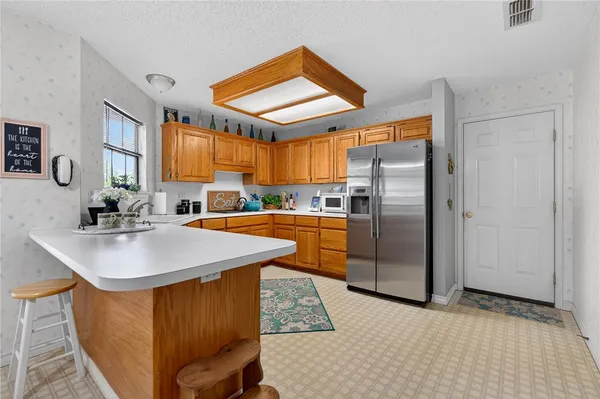 a kitchen with stainless steel appliances granite countertop a sink a refrigerator and a stove