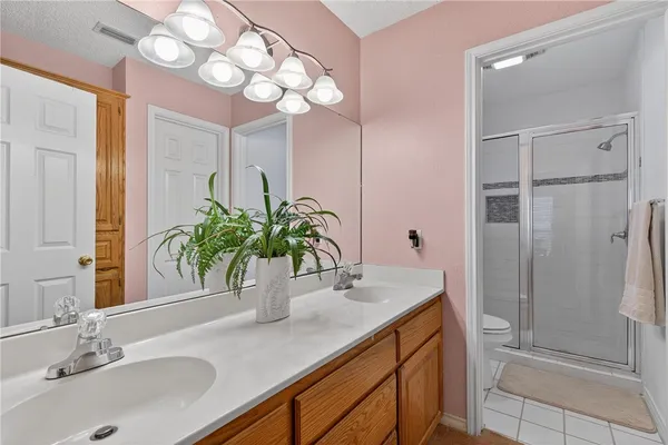 a bathroom with a granite countertop sink a large mirror and a shower