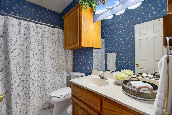 a bathroom with a granite countertop sink and a toilet