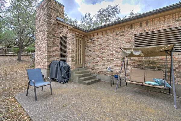 a backyard of a house with barbeque oven table and chairs