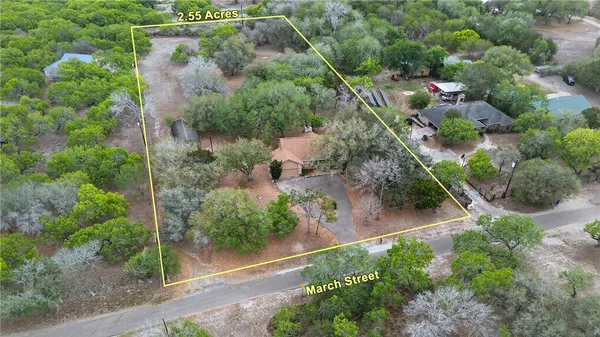 an aerial view of residential house with outdoor space and trees all around