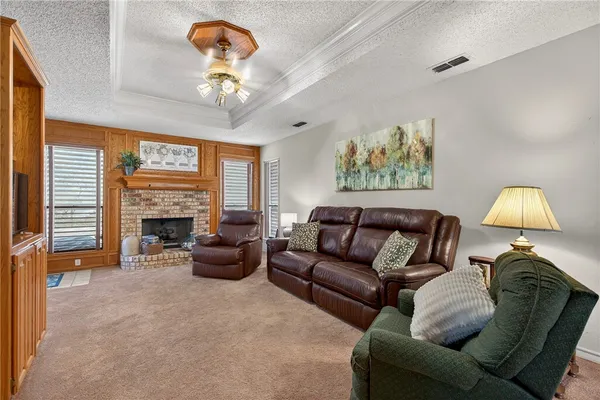 a living room with furniture a fireplace and a chandelier