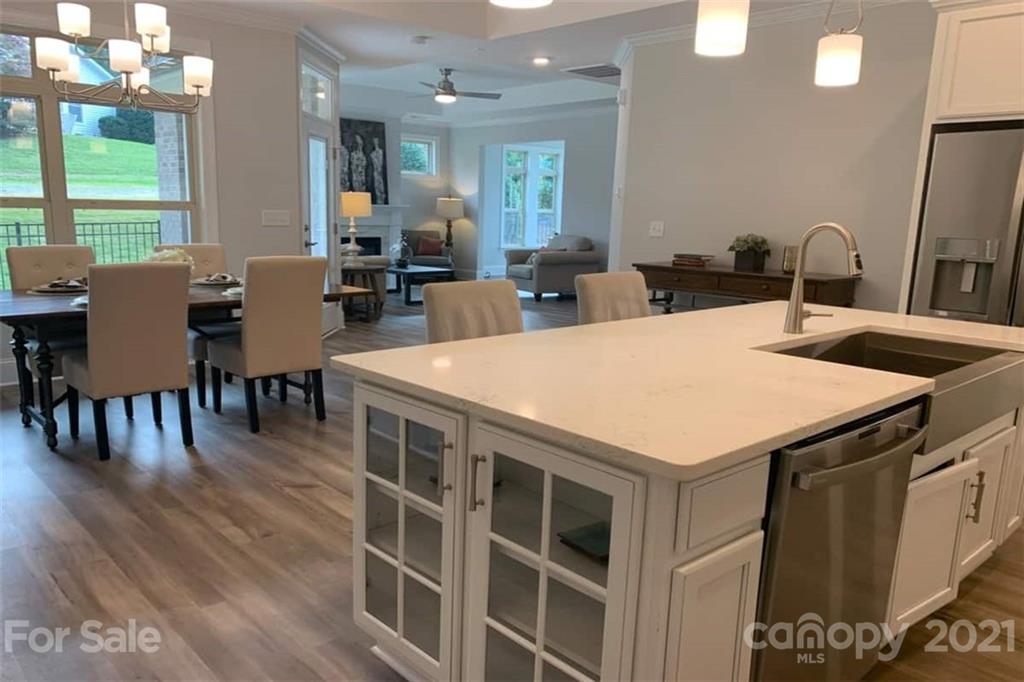 2070 New Style Way, Unit 39 Tega Cay, SC 29708 - Photo 6 of 12 a large kitchen with kitchen island a sink table and chairs