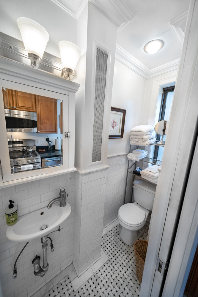 236 East 78th Street, Unit 4B Manhattan, NY 10075 - Photo 6 of 11 a bathroom with a sink a toilet a mirror and shower